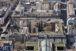 Luftaufnahme des urbanen Wohnviertels in Frankfurt am Main mit seiner gemischten Architektur und den begrünten Dächern.