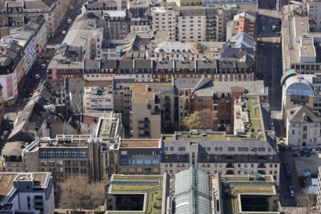 Luftaufnahme des urbanen Wohnviertels in Frankfurt am Main mit seiner gemischten Architektur und den begrünten Dächern.