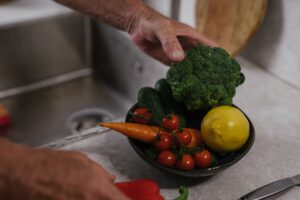 Eine Nahaufnahme von frischem Gemüse, darunter Brokkoli, Zitrone und Tomaten in einer Küche.
