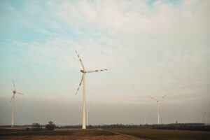 Windkraftanlagen auf einem Feld unter einem bewölkten Himmel, die saubere erneuerbare Energie gewinnen.