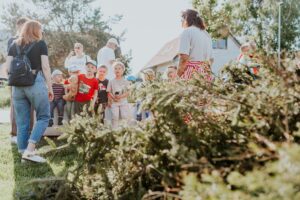 Kinder und Erwachsene nehmen an einer pädagogischen Outdoor-Aktivität inmitten der Natur teil.